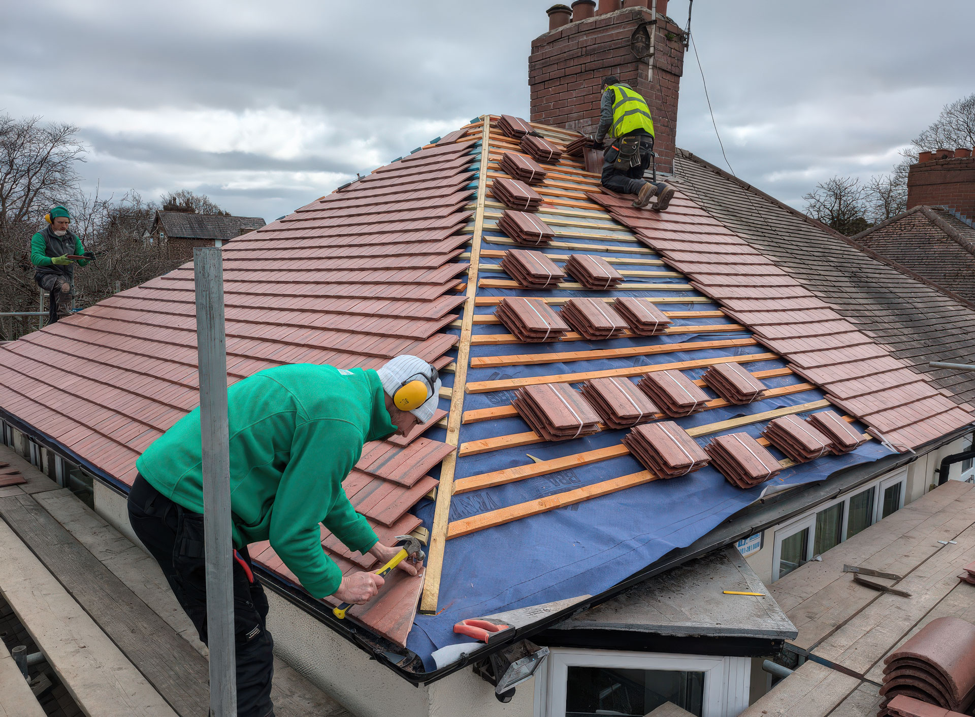 Roofers working on a tiled roof